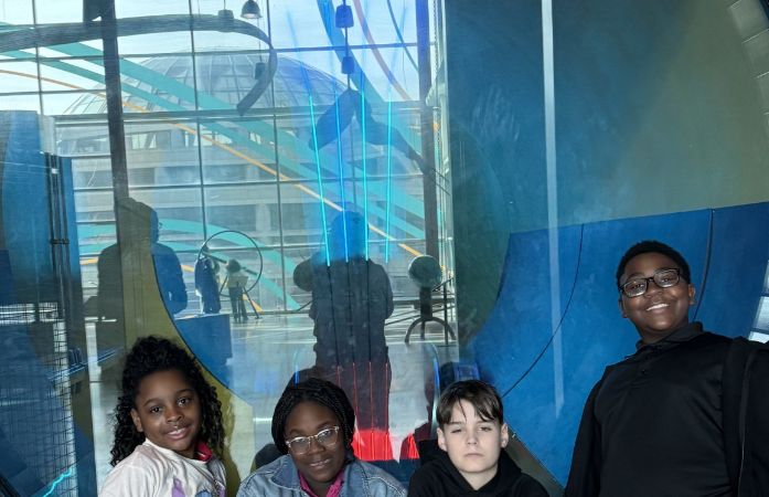  4 students standing in front of the Detroit Science Sign!
